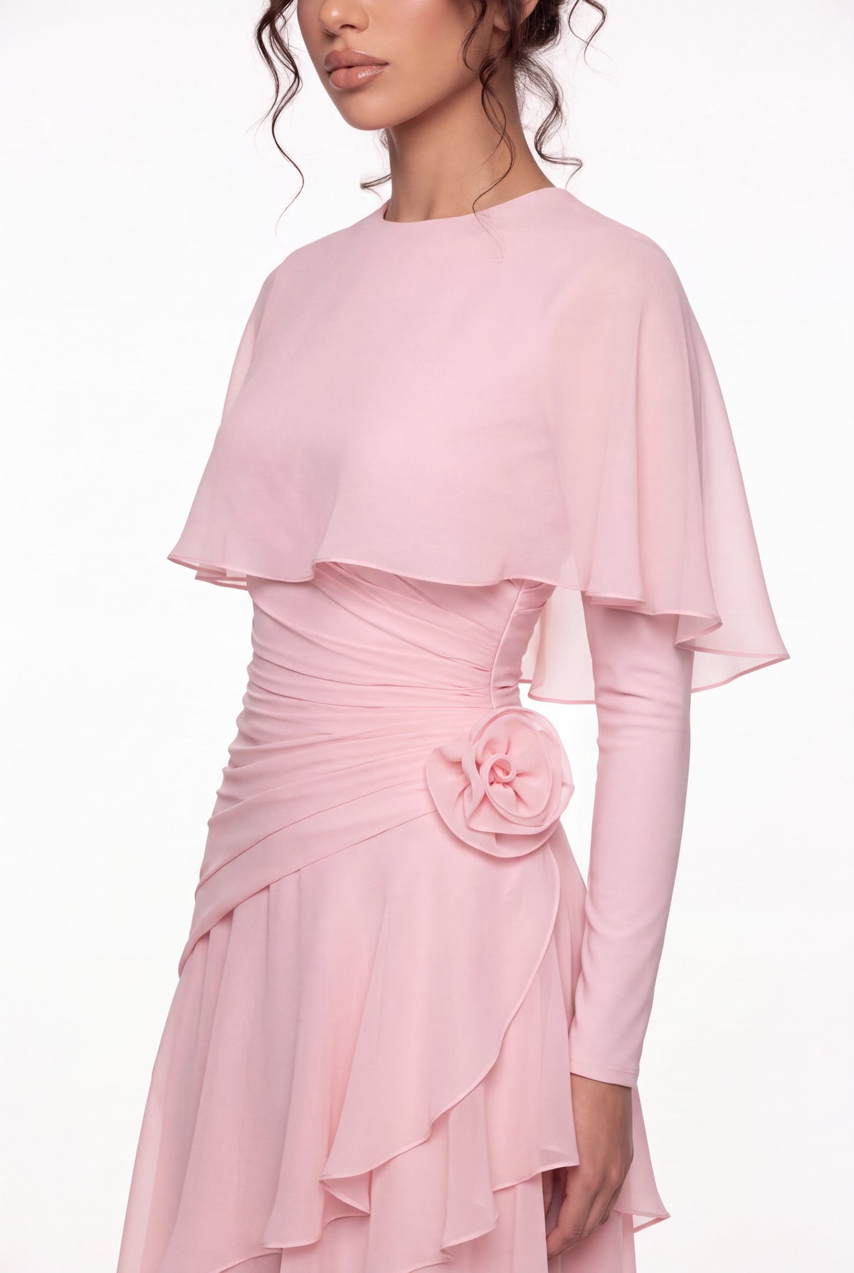 Close-up of the Athera blush pink gown: chiffon cape, gathered waist and hand-formed chiffon rose