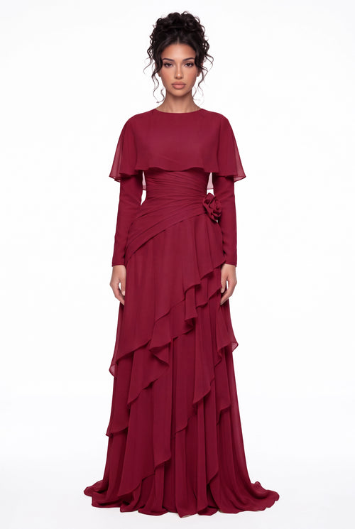 Model wearing the Athera burgundy red chiffon cape gown with long sleeves, full-length front view