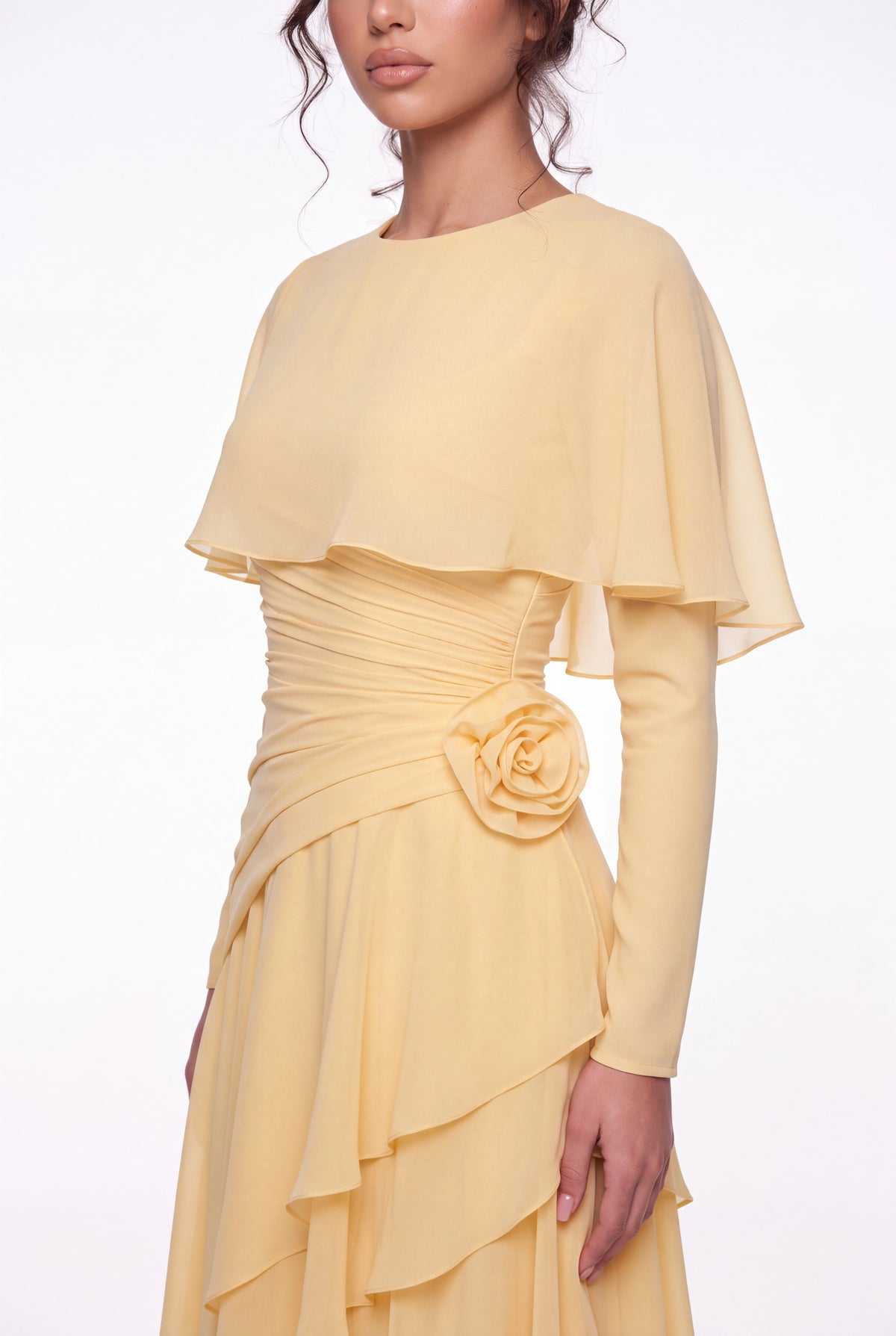 Close-up of the Athera butterfly yellow gown: chiffon cape, gathered waist and hand-formed rose