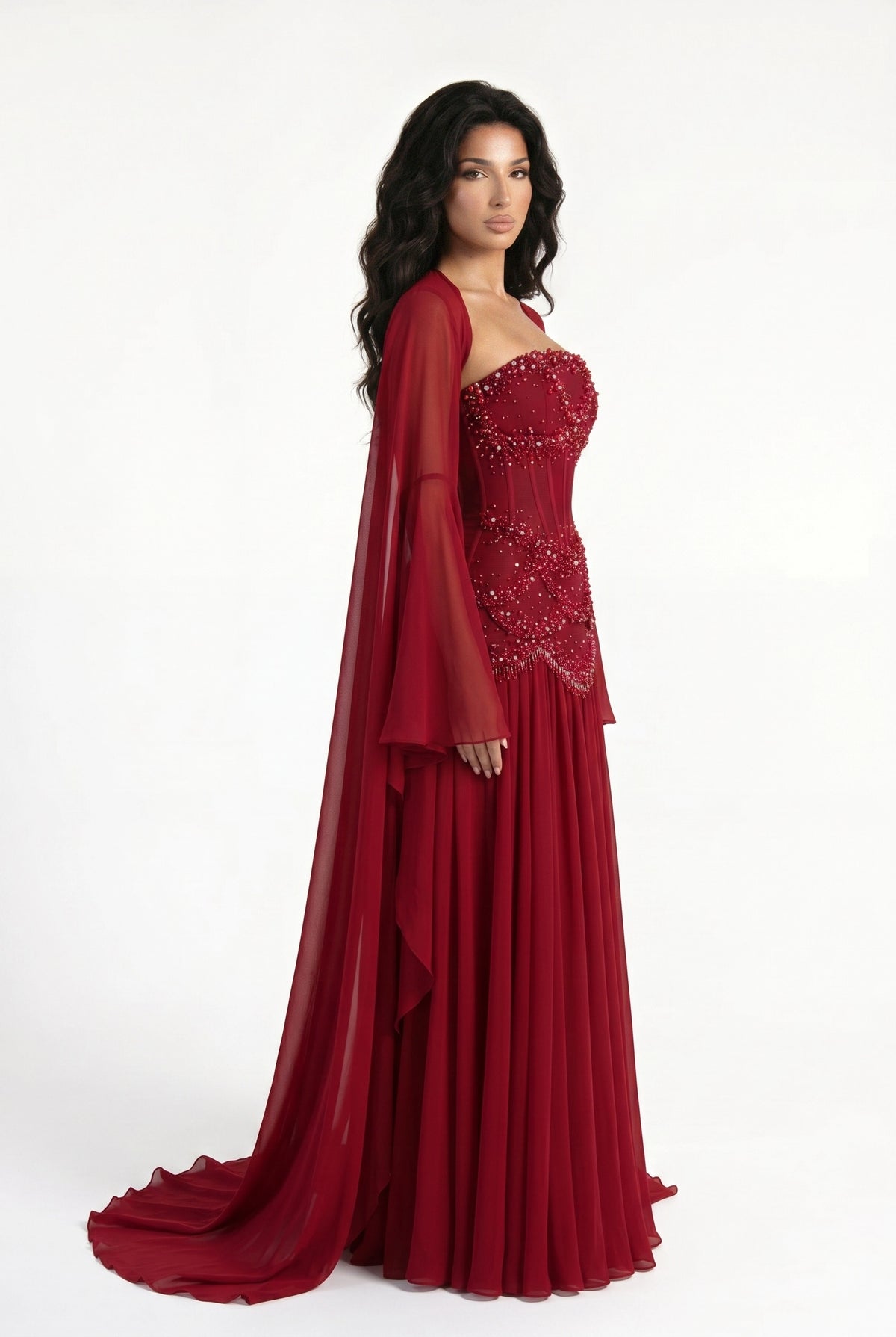 Side view of the Azura crimson red gown with long bell sleeves and floor-length chiffon skirt